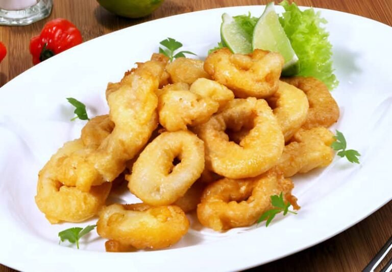 Un plato con aros de calamares a la romana y unas rodajas de limón