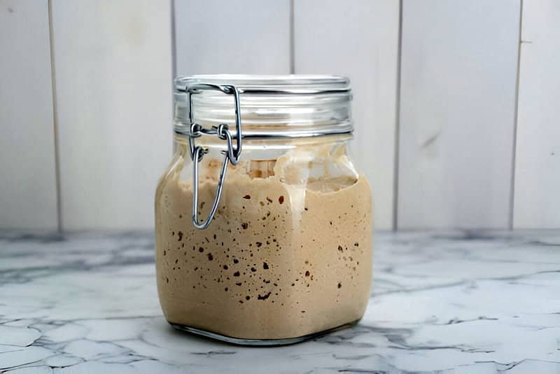 Un bote hermético con masa madre fermentada